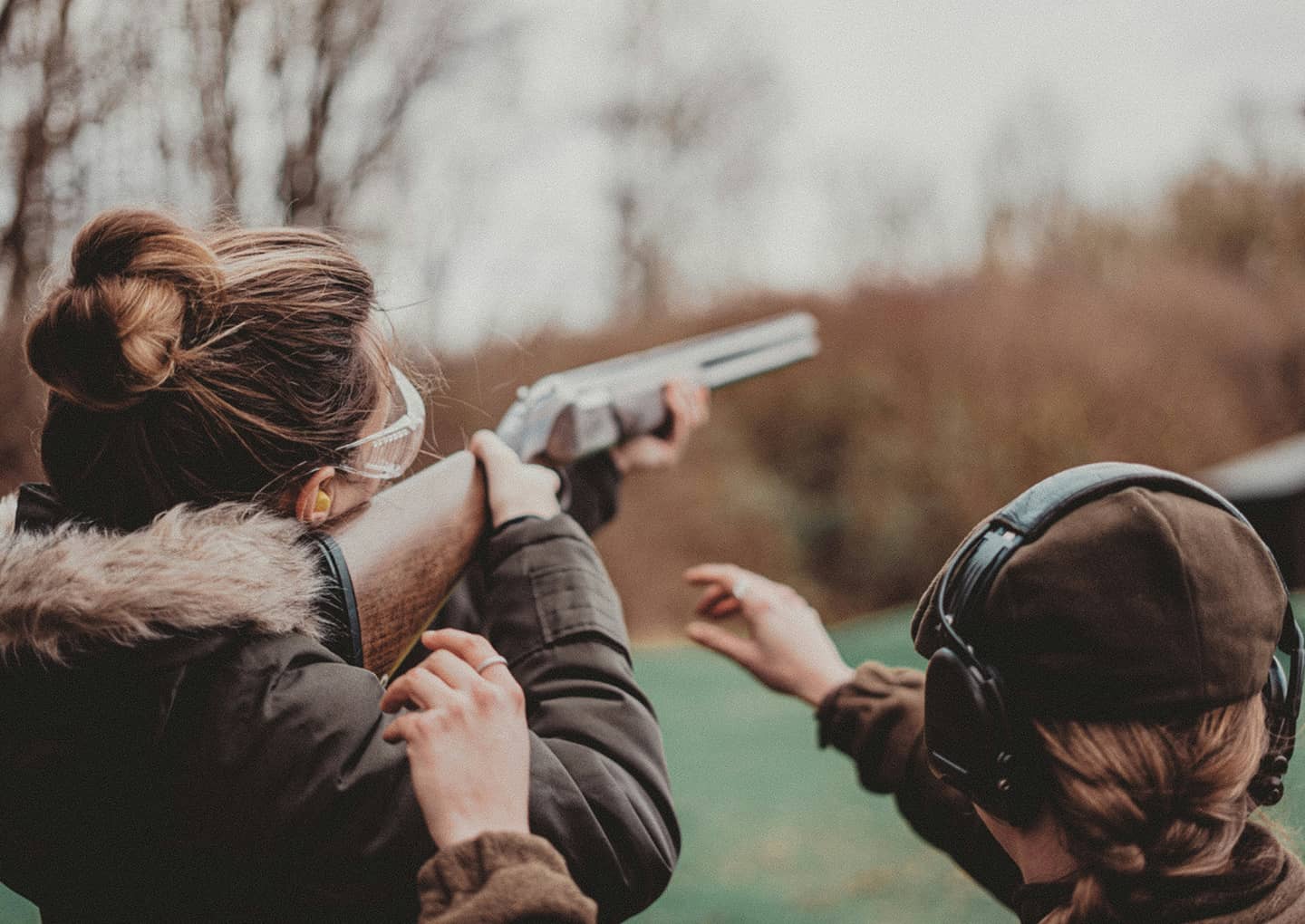 Frau mit einem Gewehr, schießt auf Tontauben
